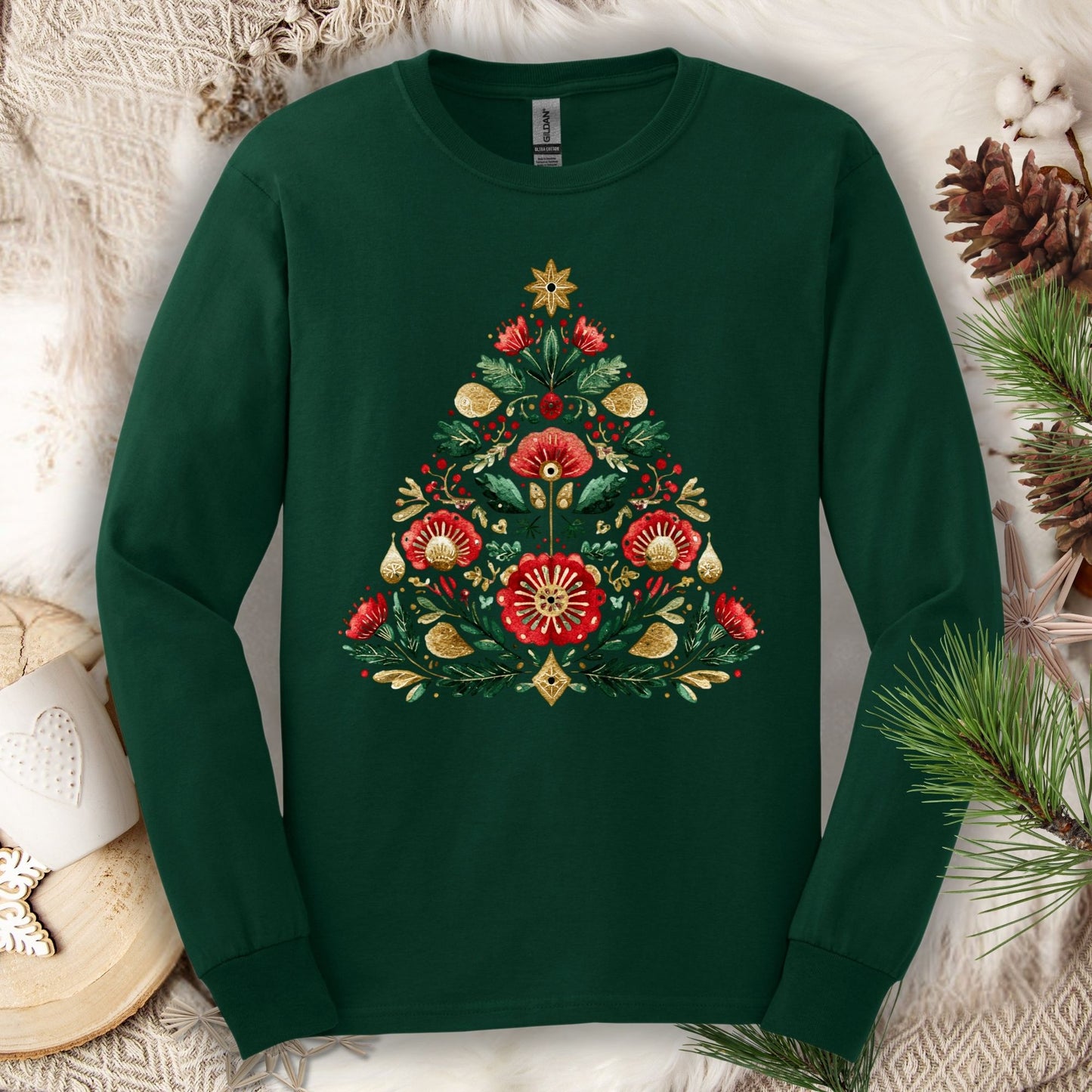 Forest green long sleeve tee with a folk art Christmas tree design in red, green, and gold.