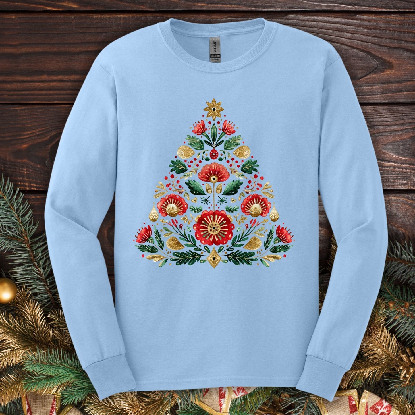 Light blue Gildan long sleeve tee with a folk art Christmas tree design in red, green, and gold.