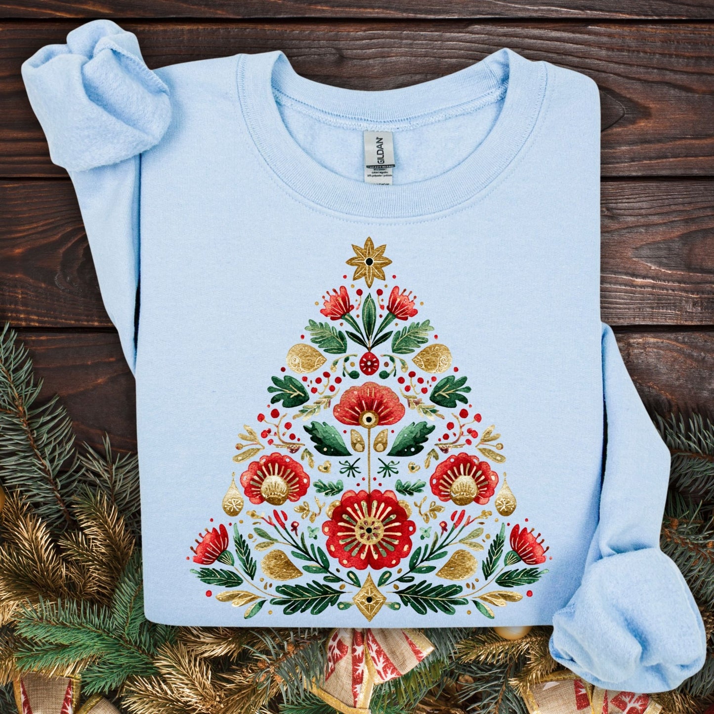 Light blue Gildan sweatshirt with a folk art Christmas tree design in red, green, and gold.