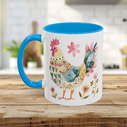 White ceramic 11oz mug with blue handle and interior, featuring a colorful watercolor folk art rooster.