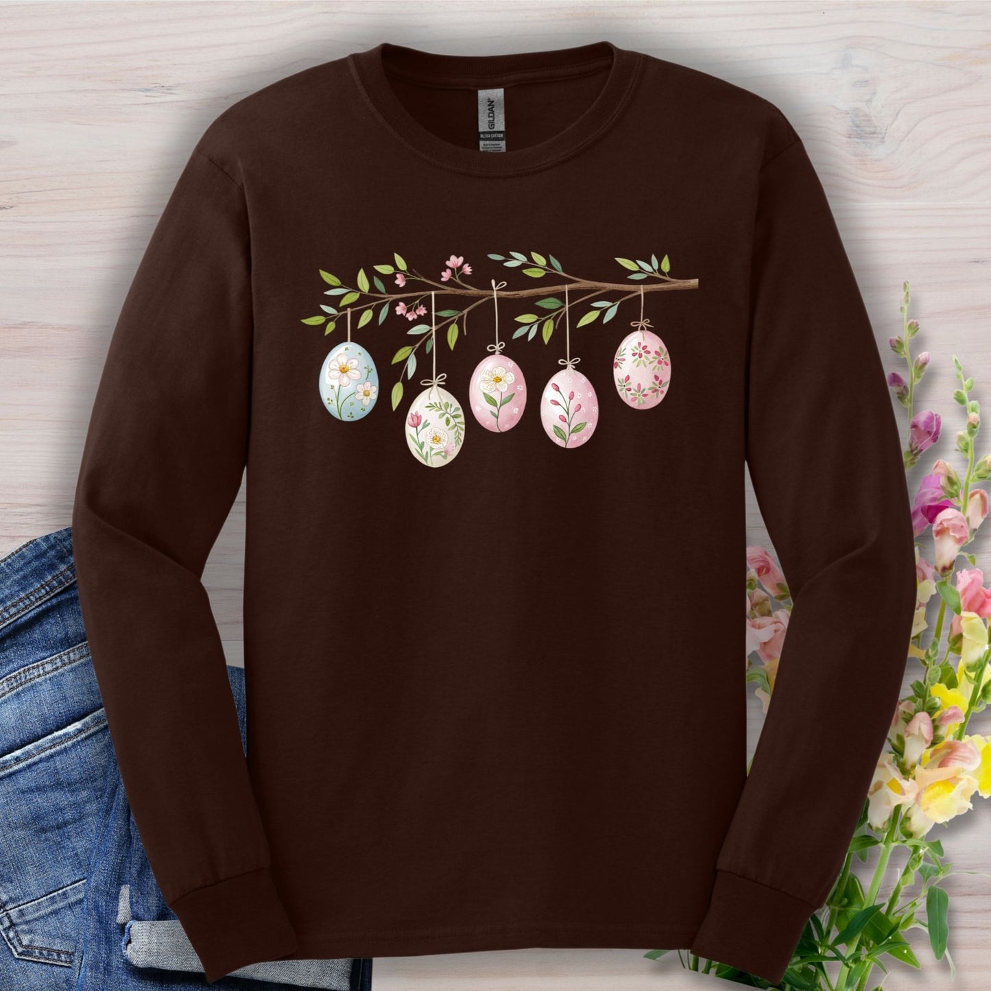 Dark chocolate long sleeve tee with a folk art branch and five watercolor Easter eggs decorated with flowers.