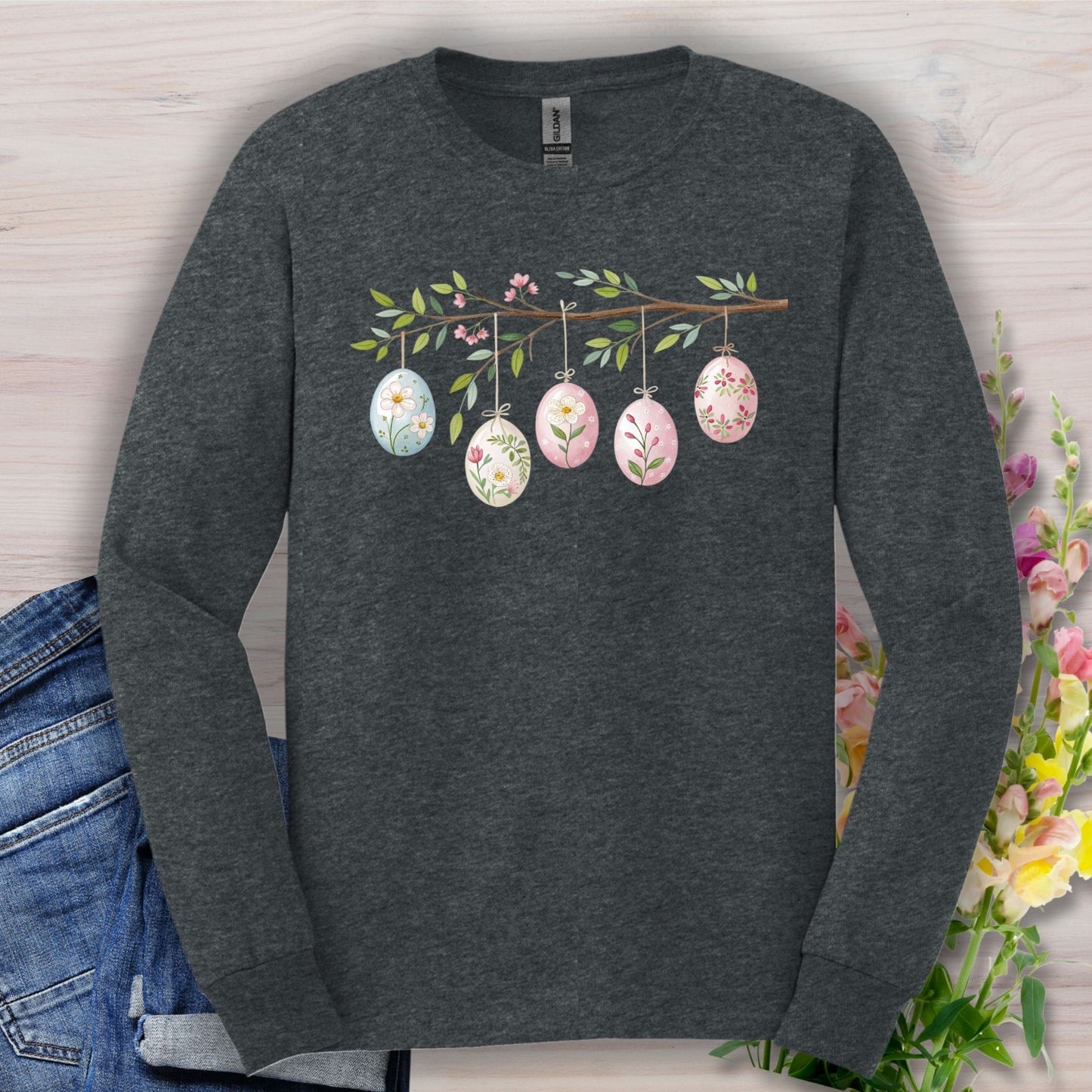 Dark heather long-sleeve tee with a folk art Easter egg branch design, featuring five floral eggs.