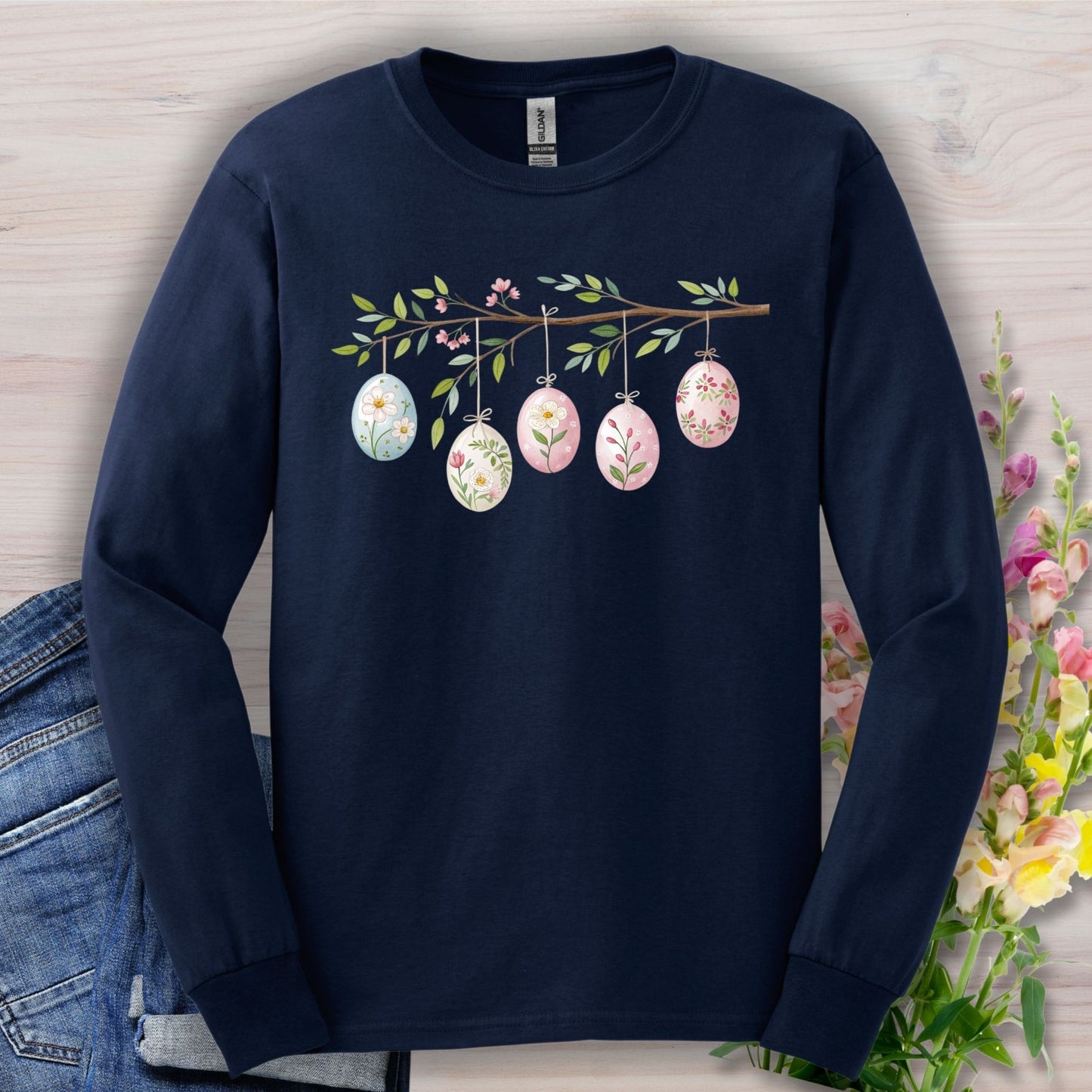 Navy long sleeve tee with a folk art branch, five hanging Easter eggs, and botanical designs.