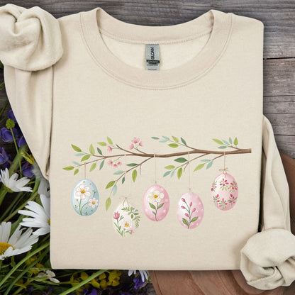 Sand S sweatshirt with a folk art Easter egg branch design, featuring five floral watercolor eggs.