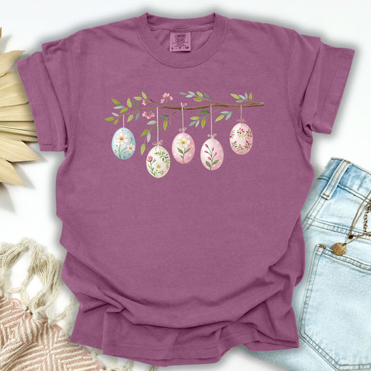 Berry S t-shirt with a folk art branch and five watercolor Easter eggs hanging from it.