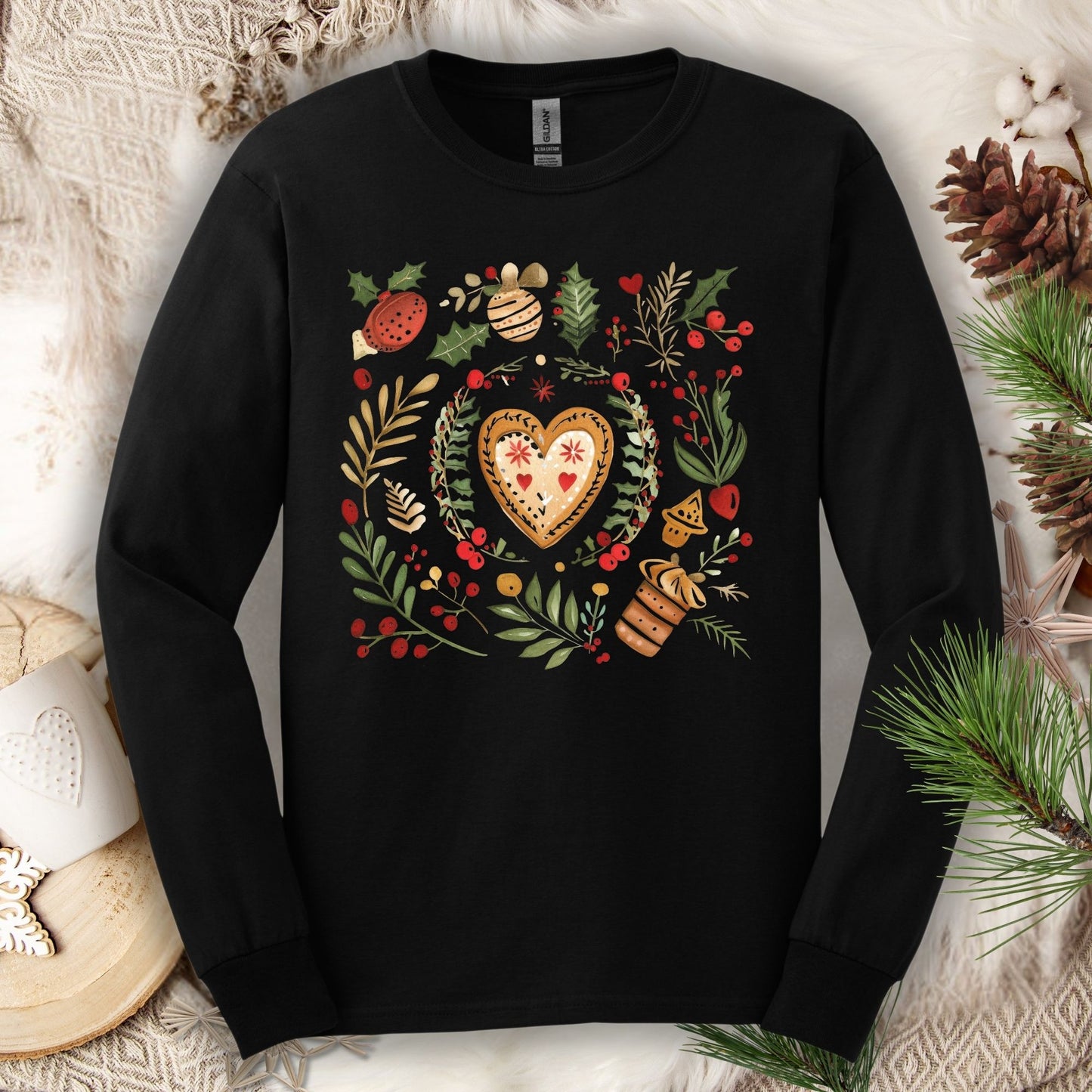 Black Gildan long sleeve tee with folk art gingerbread heart, holly, and vintage baking design.