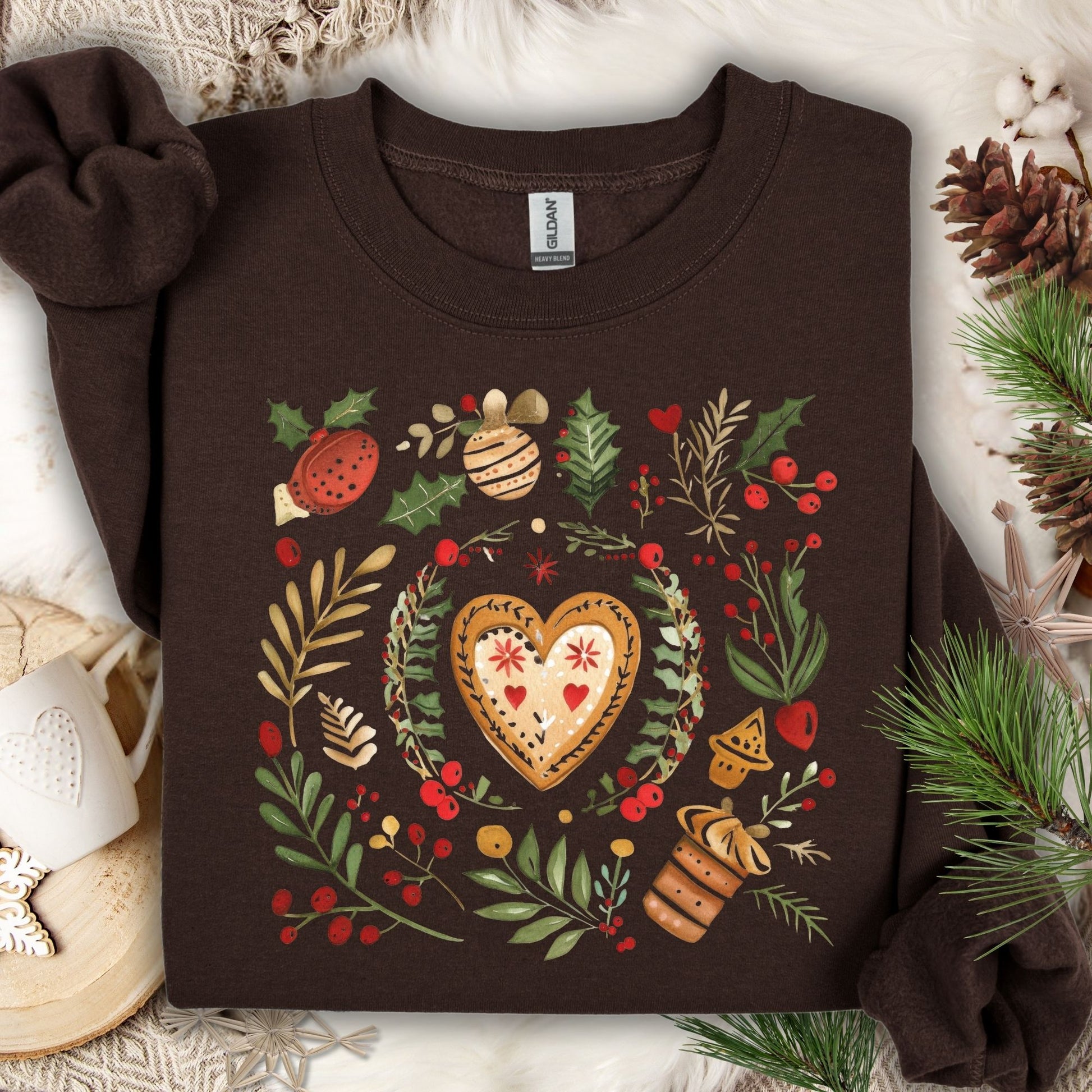 Dark chocolate Gildan sweatshirt with folk art gingerbread heart, holly, and berries design.