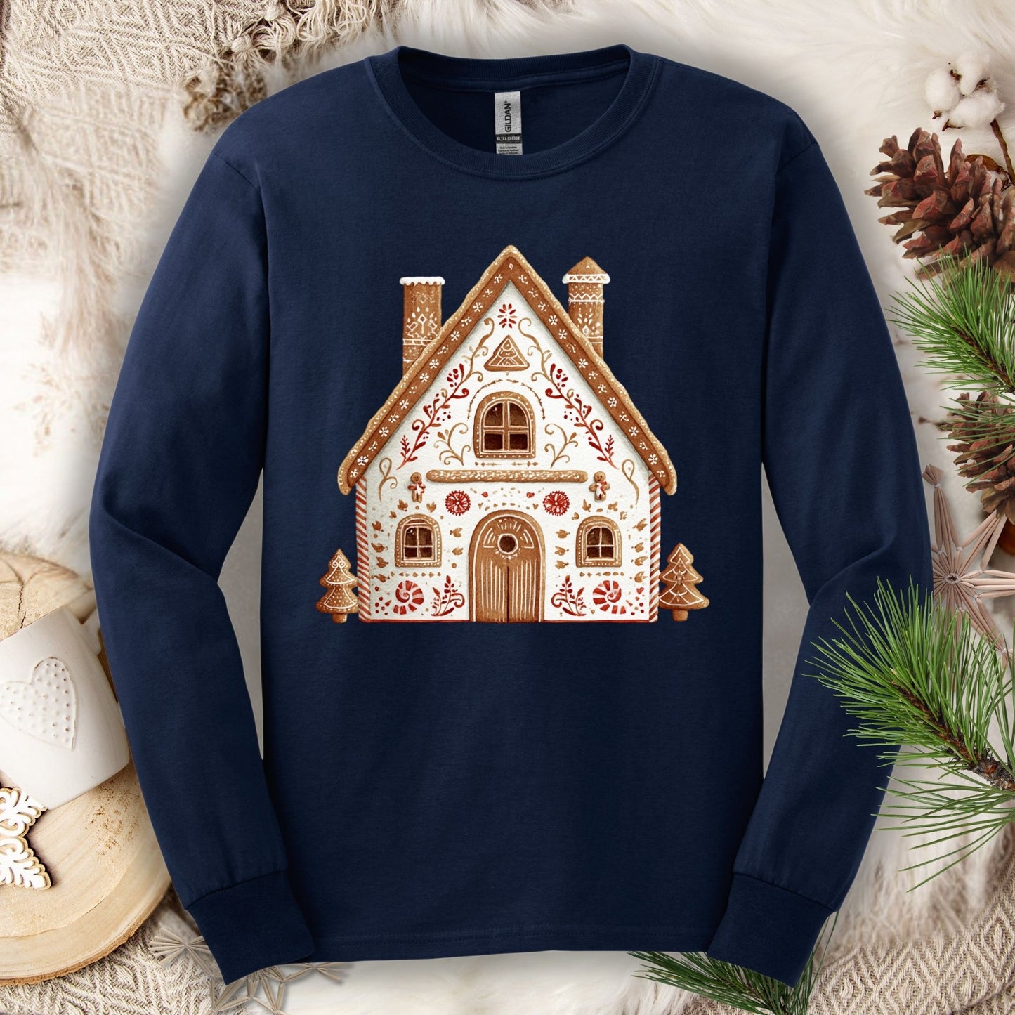 Navy long sleeve tee with a folk art gingerbread house design in watercolor tones.