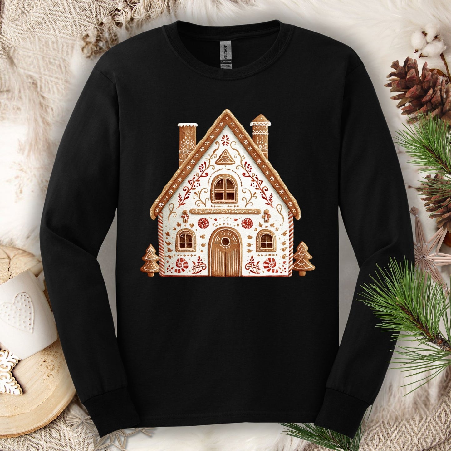 Black Gildan long sleeve tee with a folk art gingerbread house design in watercolor tones.