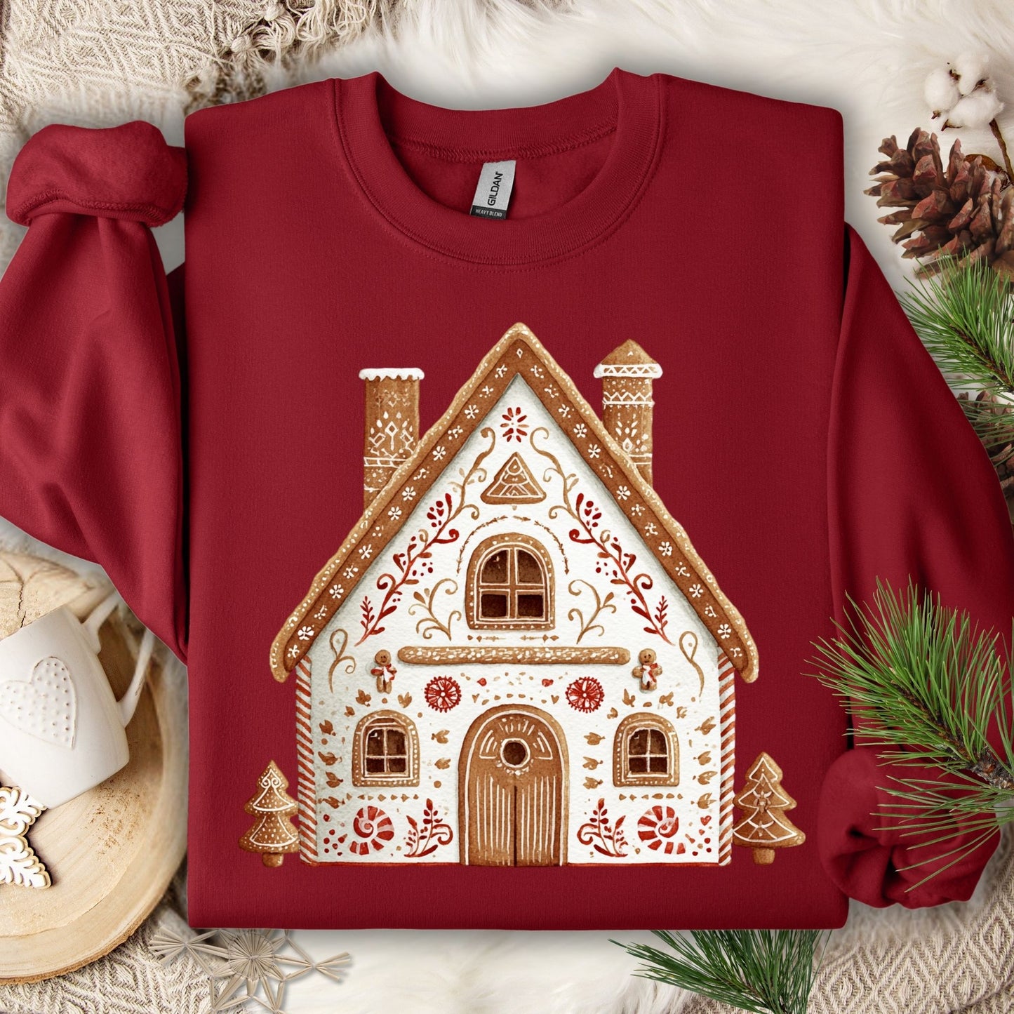 Garnet Gildan sweatshirt with a folk art gingerbread house design, featuring white icing details and brown trim.