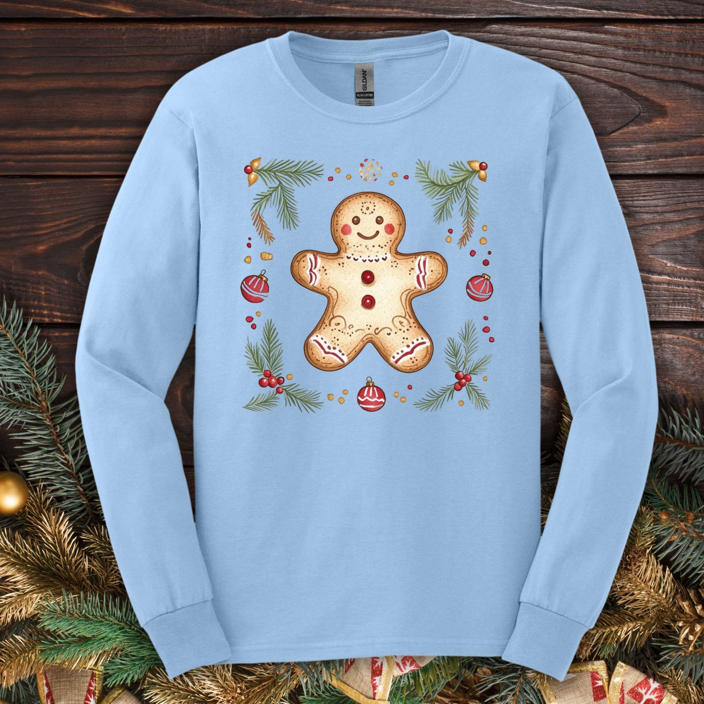 Light blue long sleeve tee with a folk art gingerbread man, pine, and ornaments.
