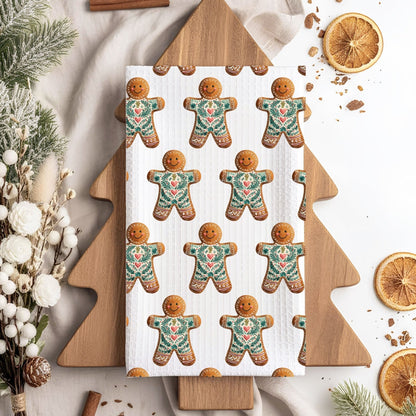 Microfiber tea towel with folk art gingerbread man pattern on a wooden tree-shaped board.