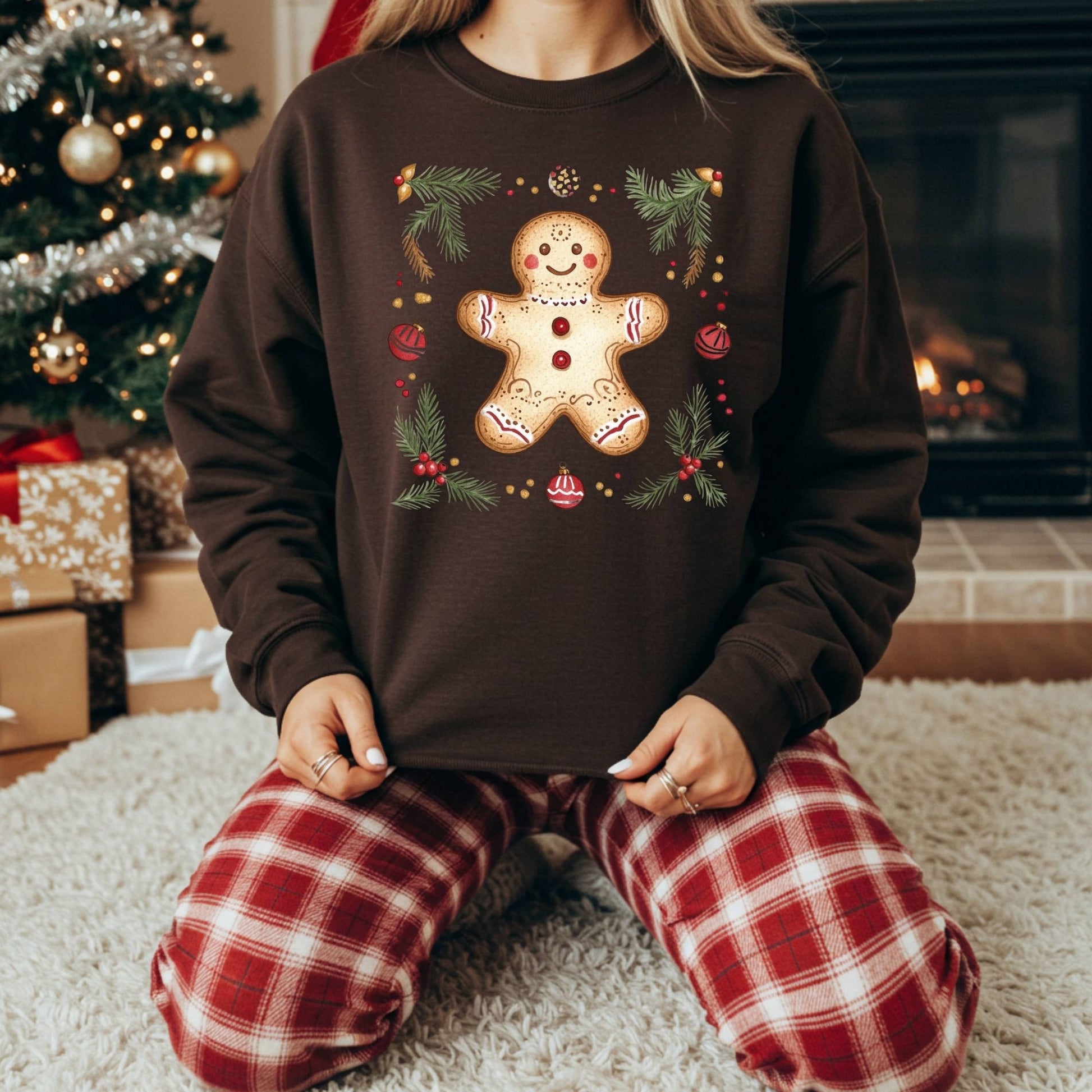 Brown Gildan sweatshirt with a folk art gingerbread man, holly, and evergreen design.