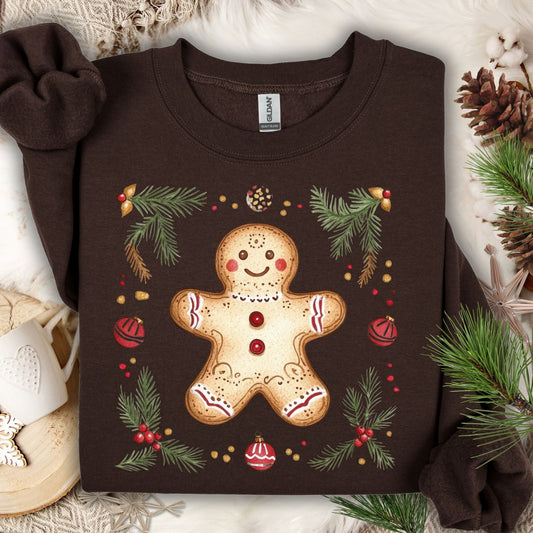 Dark Chocolate Gildan sweatshirt with a folk-art gingerbread man, holly berries, and evergreen flourishes.