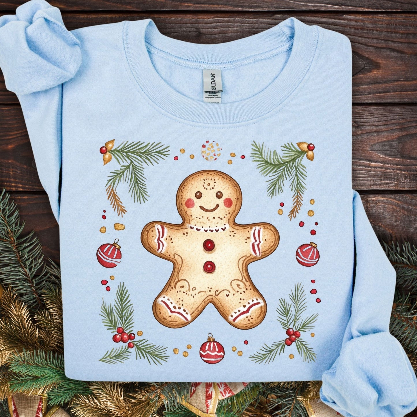Light blue Gildan sweatshirt with a folk art gingerbread man, holly, and evergreen design.