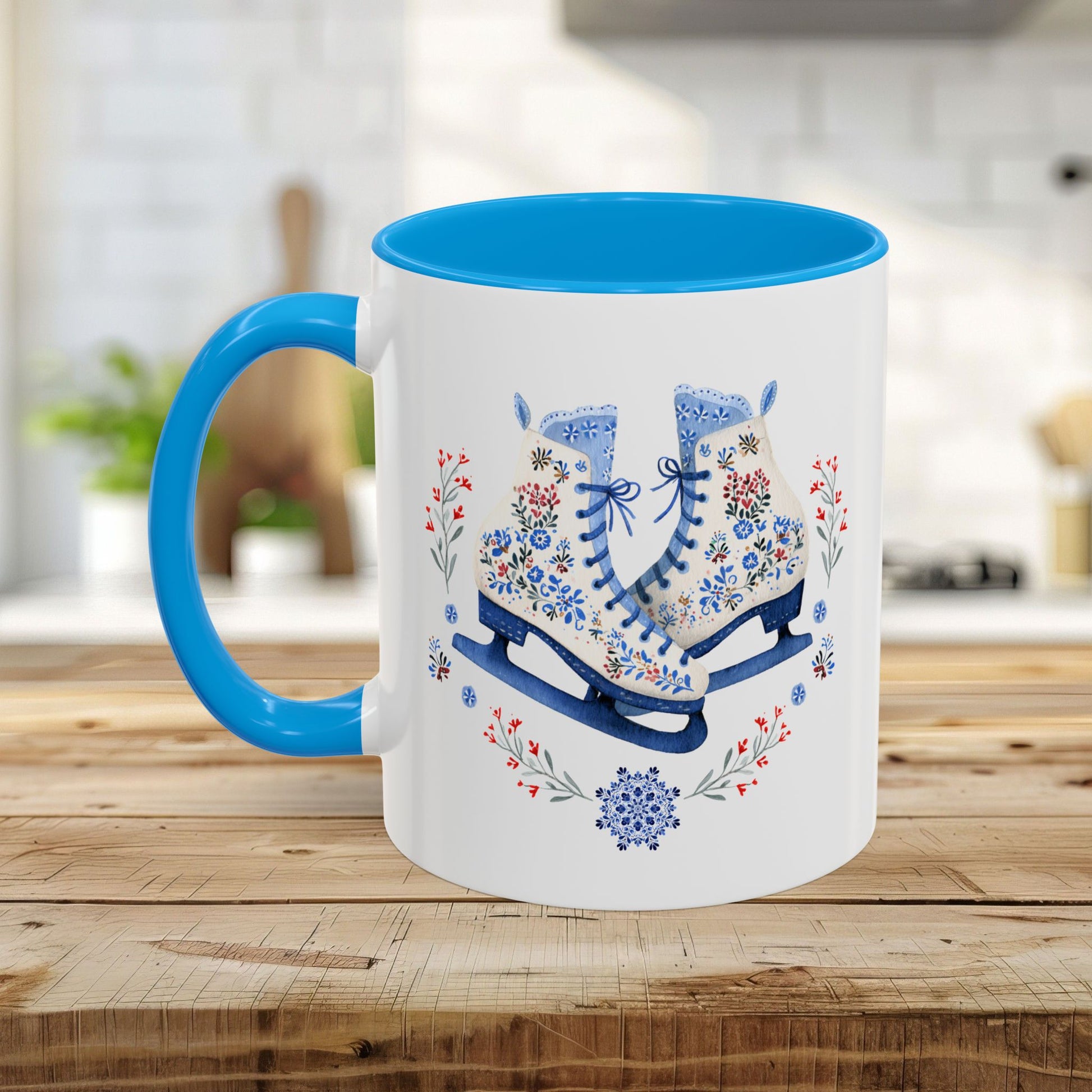 White ceramic mug with blue handle and interior, featuring folk art ice skates, snowflakes, and winter berries.