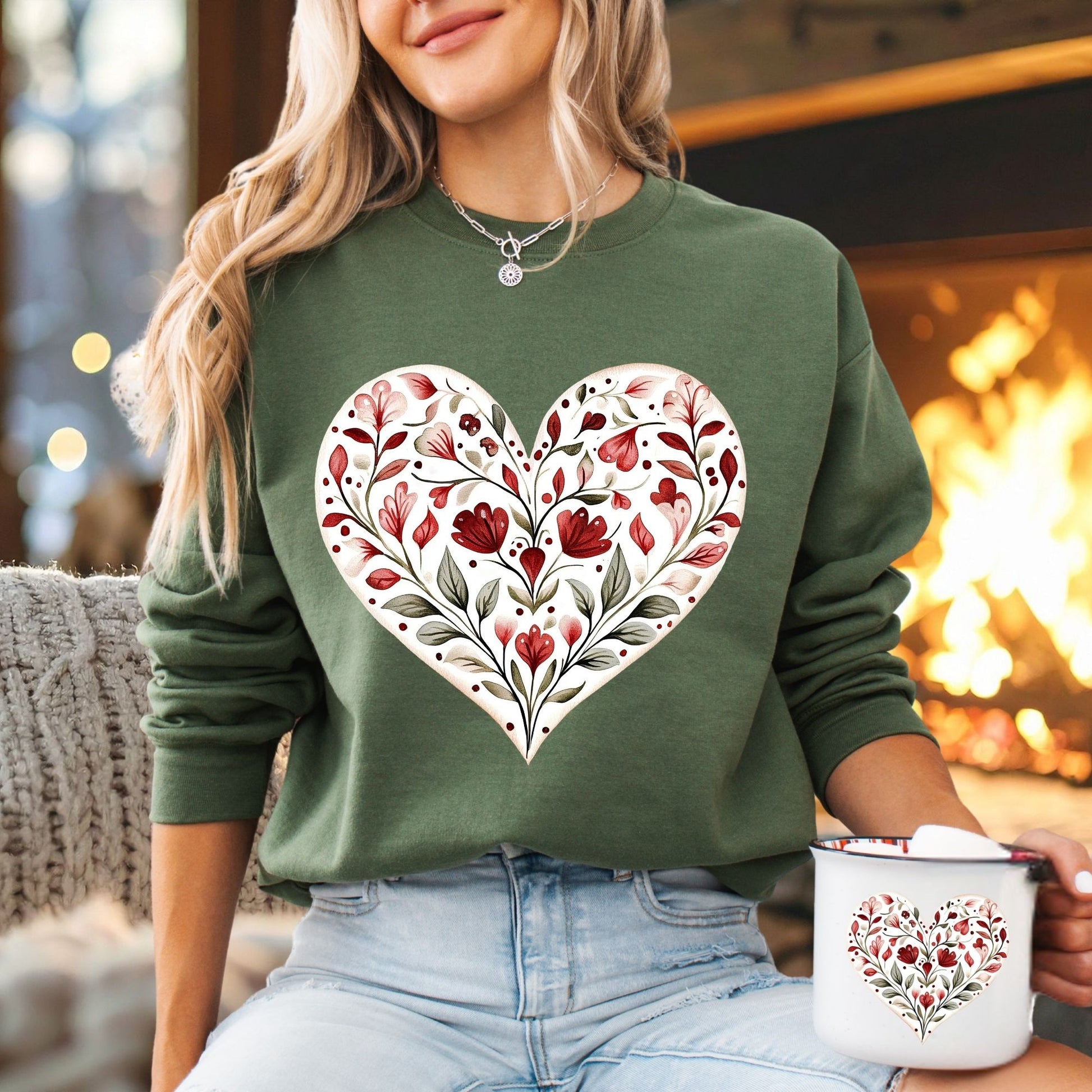 Folk art green sweatshirt with a white heart filled with red floral and green leaf designs.