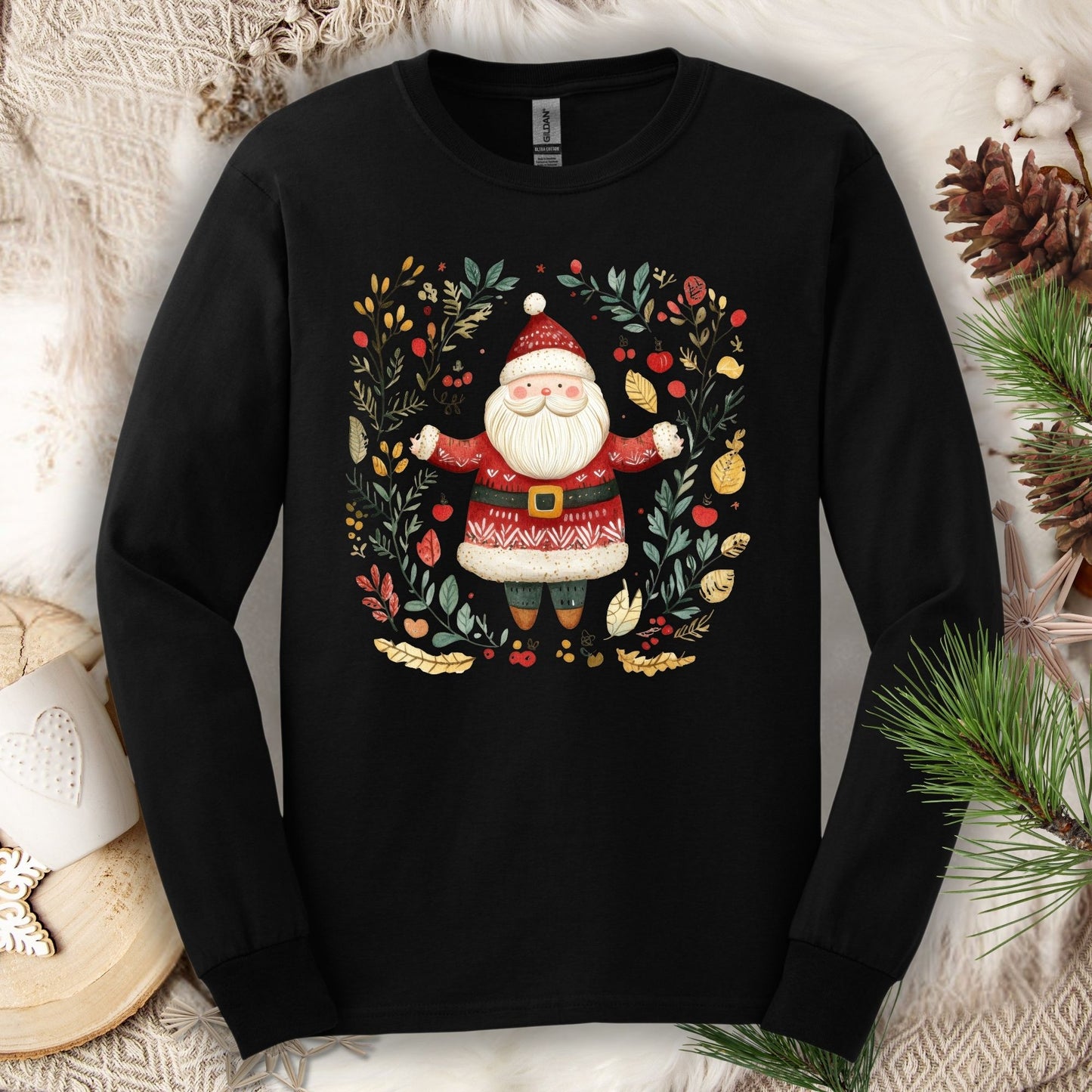 Black Gildan Softstyle long sleeve tee with folk art Santa in a wreath of evergreen, holly, and berries.