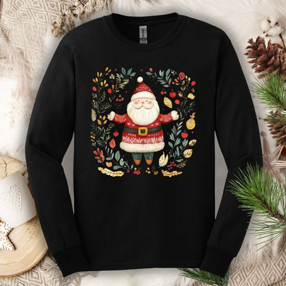 Black Gildan Softstyle long sleeve tee with folk art Santa in a wreath of evergreen, holly, and berries.