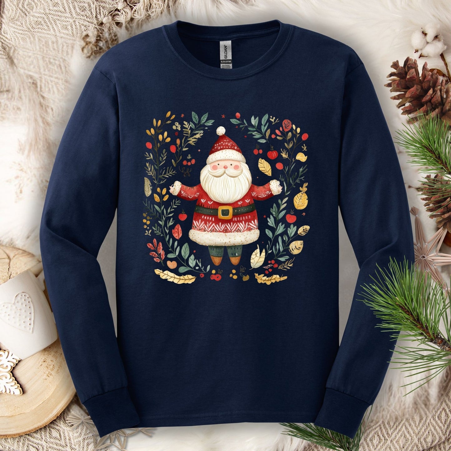 Navy long sleeve tee with a folk art Santa in a wreath of evergreen, holly, and berries.