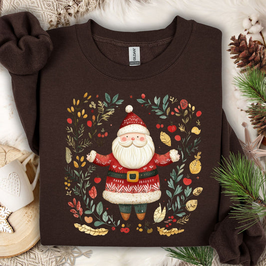 Dark chocolate fleece sweatshirt with a folk art Santa in a wreath of evergreens, holly, and golden accents.