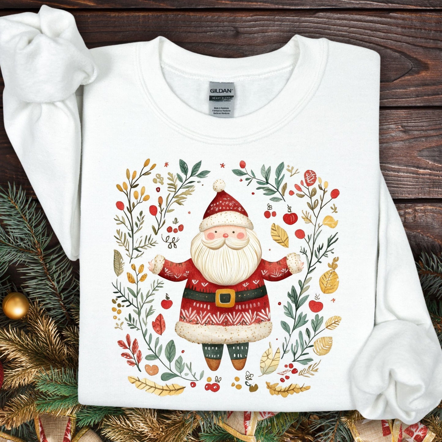 White Gildan fleece sweatshirt with a folk art Santa in a wreath of evergreens, holly, and golden accents.