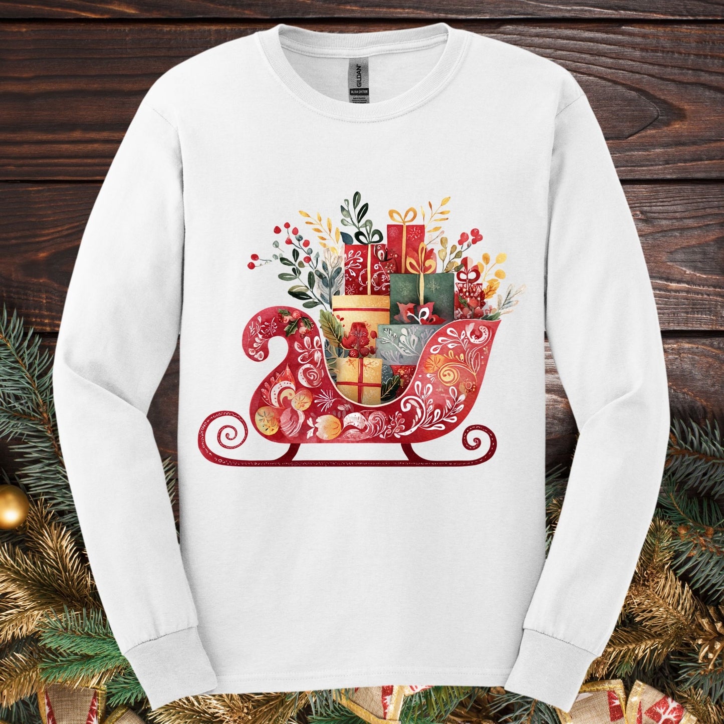 White Gildan long sleeve tee with a folk art red sleigh brimming with festive gifts in European hues.