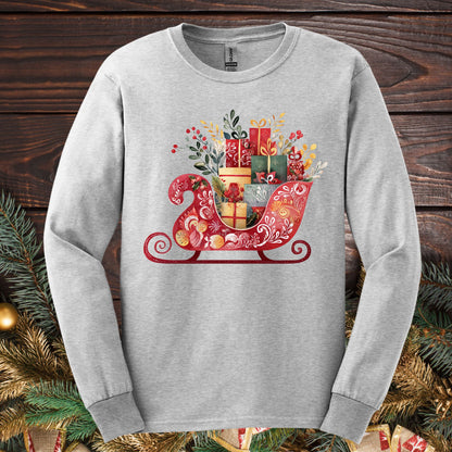 Ash Gildan long sleeve tee with a folk art Old World Christmas sleigh design, brimming with festive gifts.