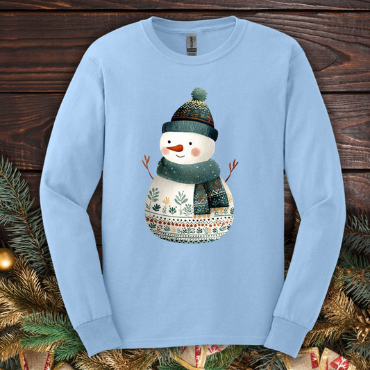 Light blue Gildan long sleeve tee with a folk art snowman in a teal hat and scarf.