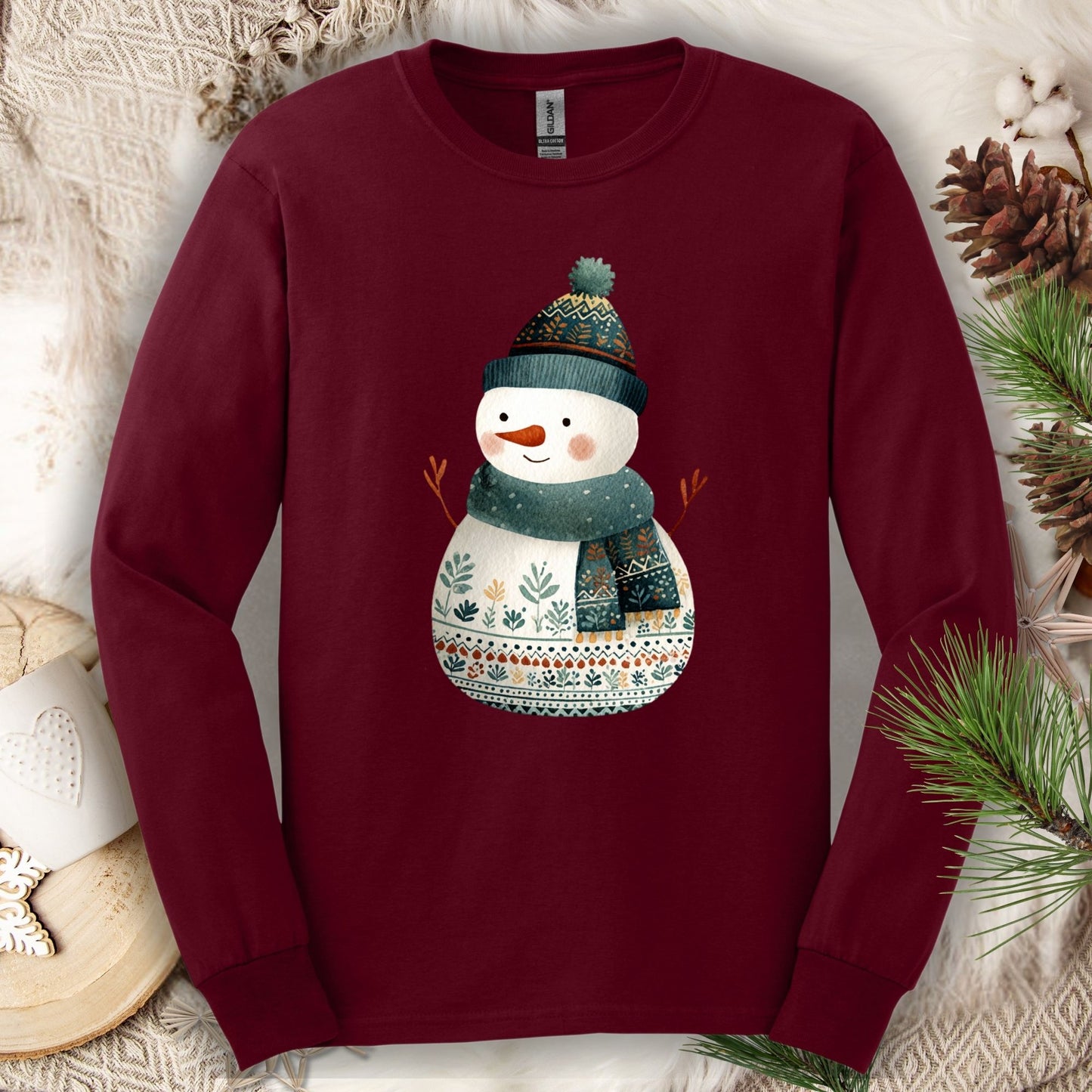 Maroon Gildan long sleeve tee with a folk art snowman in a teal hat and scarf.