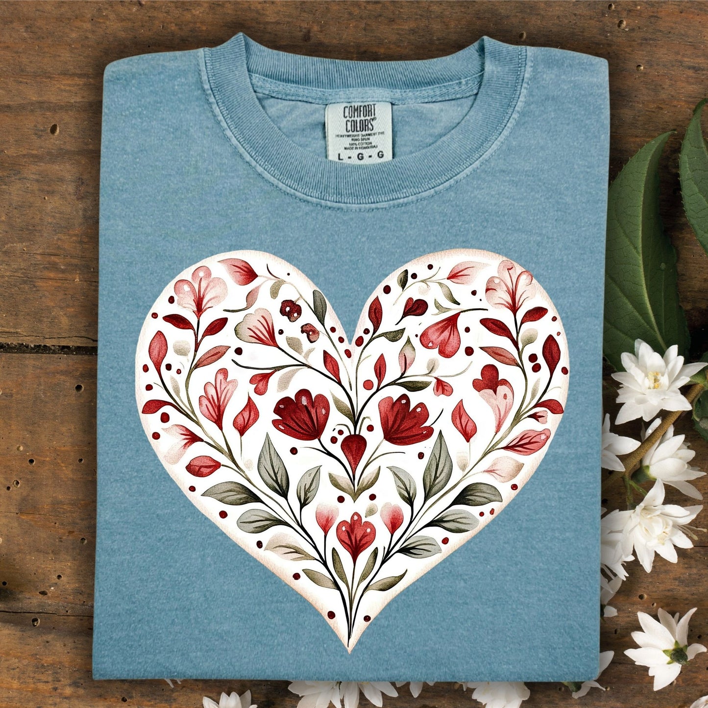 Folded, relaxed-fit, garment-dyed blue cotton t-shirt with a painterly red floral heart design.