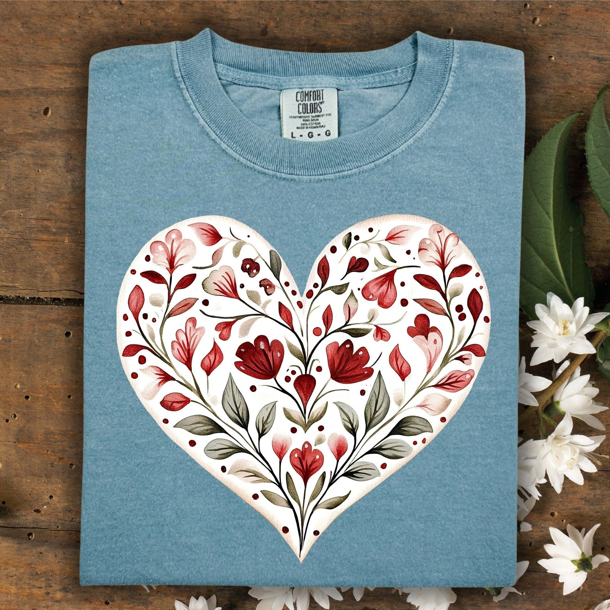 Folded, relaxed-fit, garment-dyed blue cotton t-shirt with a painterly red floral heart design.