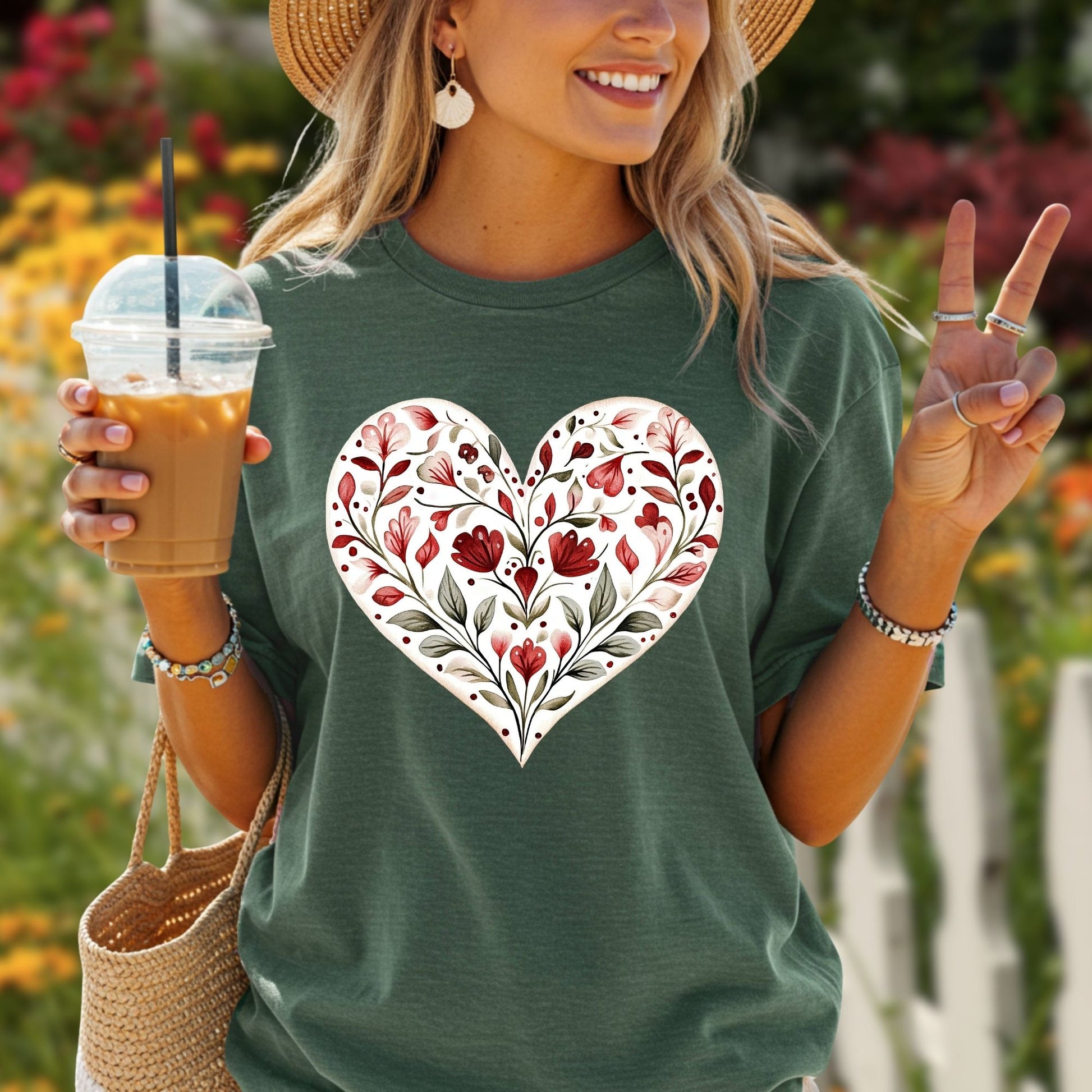 Woman in a relaxed-fit, garment-dyed green cotton t-shirt with a red floral heart design.