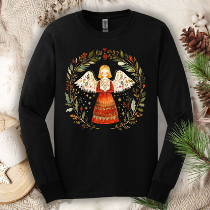 Black Gildan Softstyle long sleeve tee with a folk art winter angel in a red dress surrounded by a festive wreath.