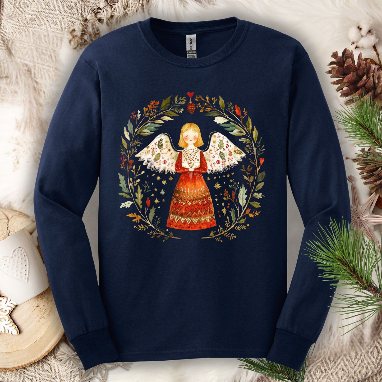 Navy Gildan Softstyle long sleeve tee with folk art winter angel in a wreath of red, green, and gold.