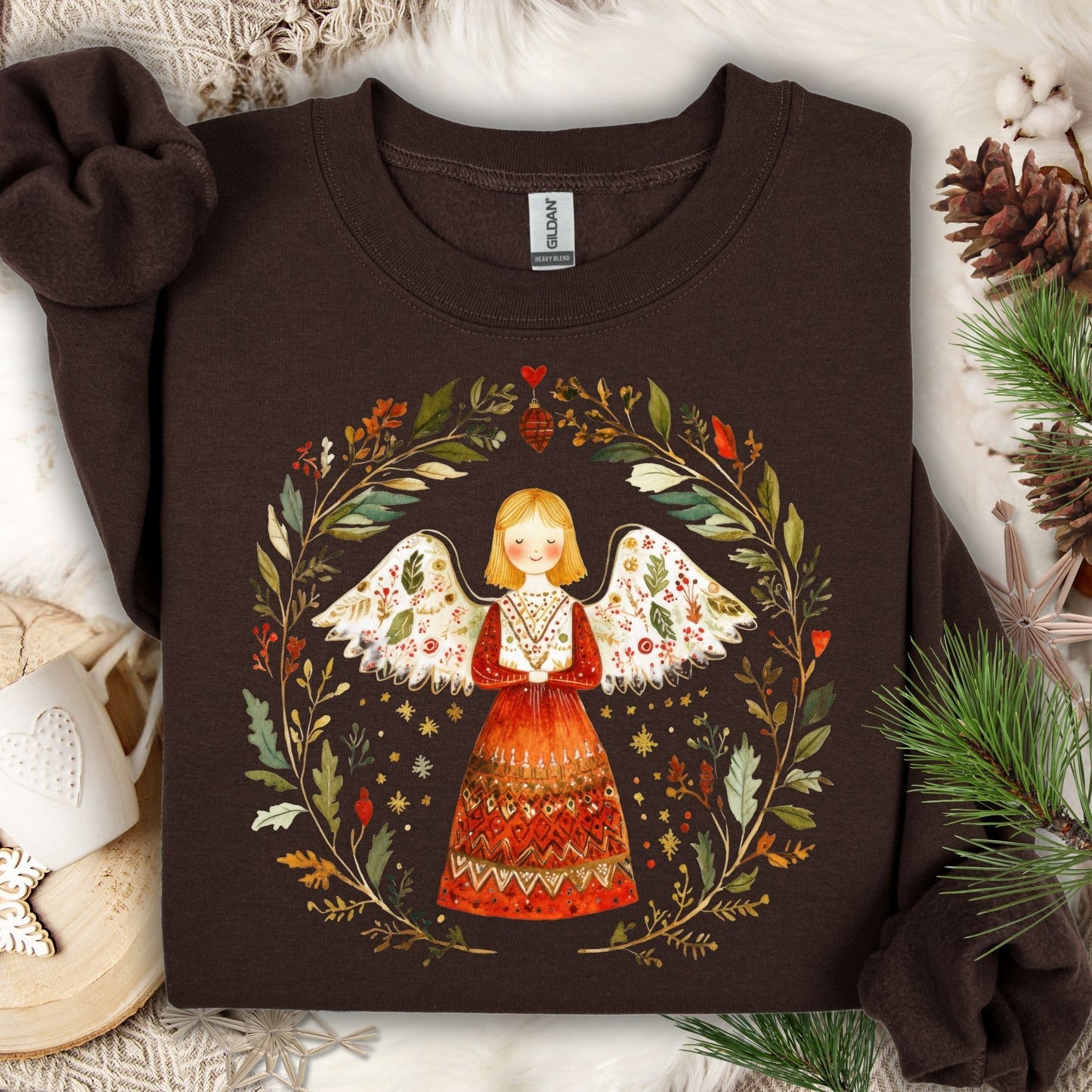 Dark Chocolate S sweatshirt with a folk art angel in a winter wreath design, surrounded by festive decor.