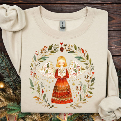 Sand S sweatshirt with a folk art angel in a winter wreath, featuring red, green, and golden hues.