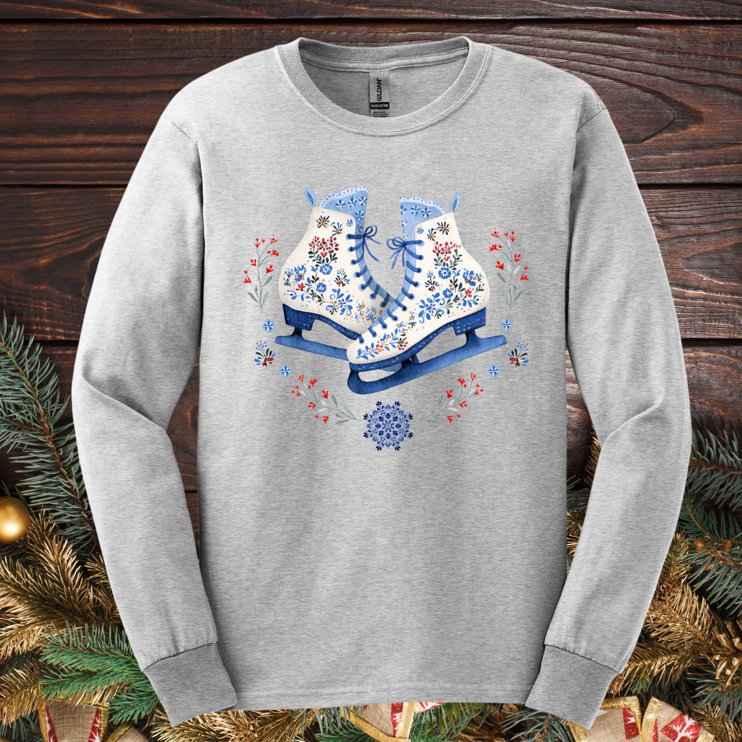 Ash long sleeve tee with folk art winter ice skates in blue, red, and white floral patterns.