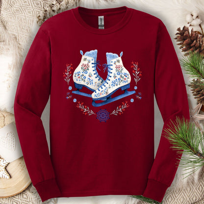 Cardinal Red long sleeve tee with folk art ice skates in blue, red, and white florals, surrounded by winter greenery.