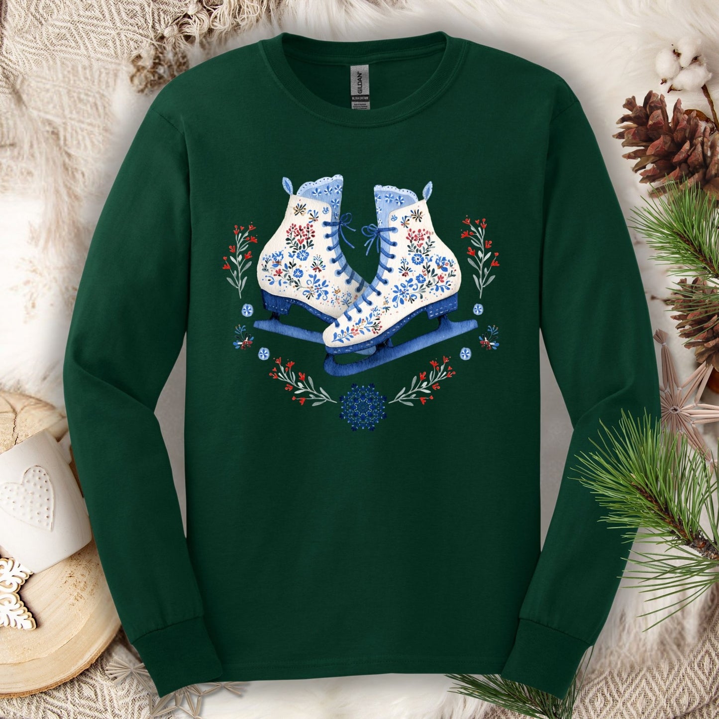 Forest Green long sleeve tee with folk art winter ice skates in blue, red, and white floral designs.