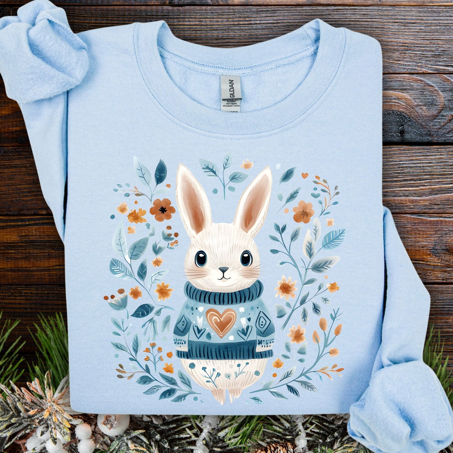 Light blue Folk Art Winter Rabbit sweatshirt with a cute bunny in a knitted sweater and floral frame.
