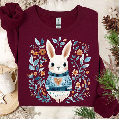 Maroon Folk Art Winter Rabbit sweatshirt with a whimsical bunny in a blue sweater, surrounded by floral designs.