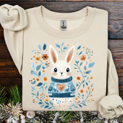 Sand Folk Art Winter Rabbit sweatshirt with a bunny in a blue sweater, surrounded by floral designs.