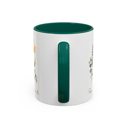 White ceramic mug with a green handle and interior, featuring watercolor wildflowers and "Free Spirit" script.