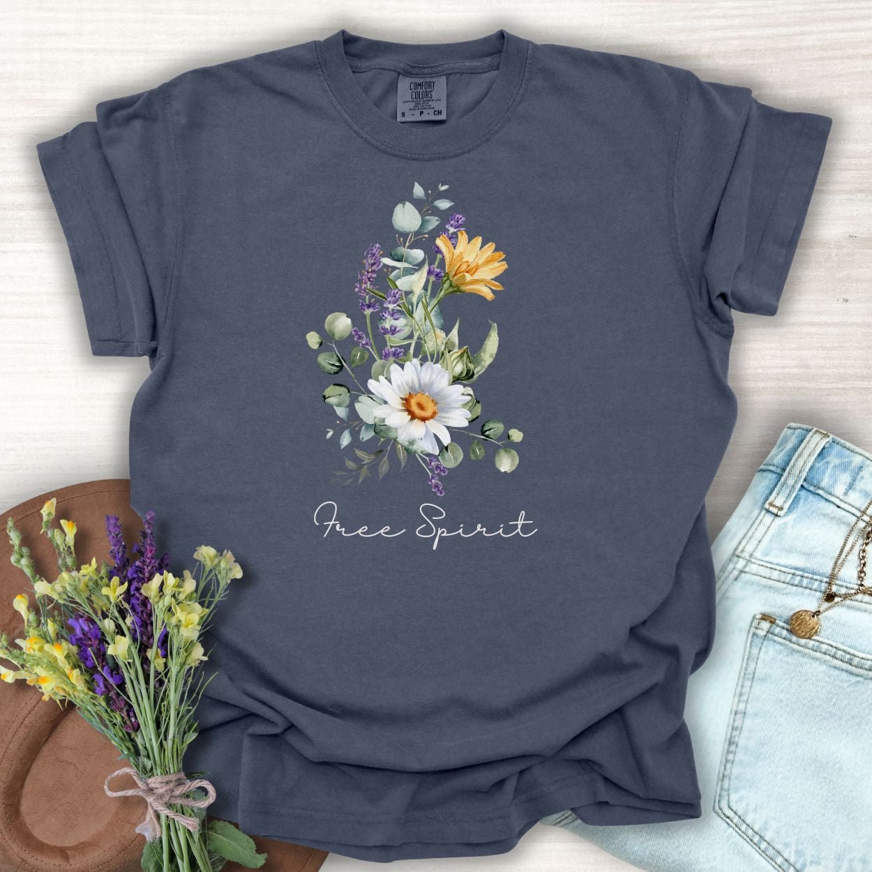 Denim S t-shirt with a hand-painted daisy, lavender, eucalyptus bouquet and "Free Spirit" script.
