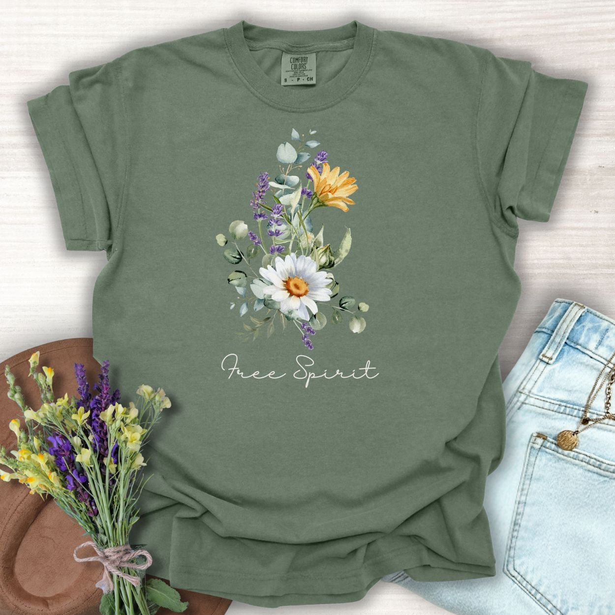 Moss green relaxed-fit t-shirt with a hand-painted daisy, lavender, eucalyptus bouquet and "Free Spirit" script.