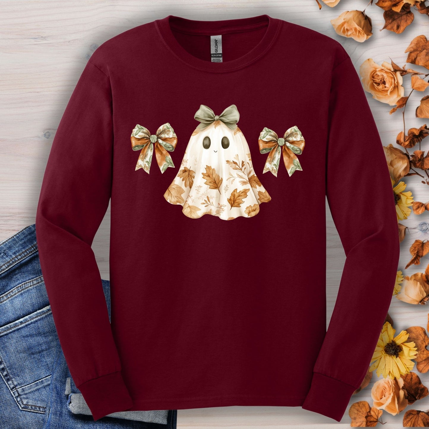 Maroon long-sleeve tee with a friendly ghost design, fall leaves, and bows.