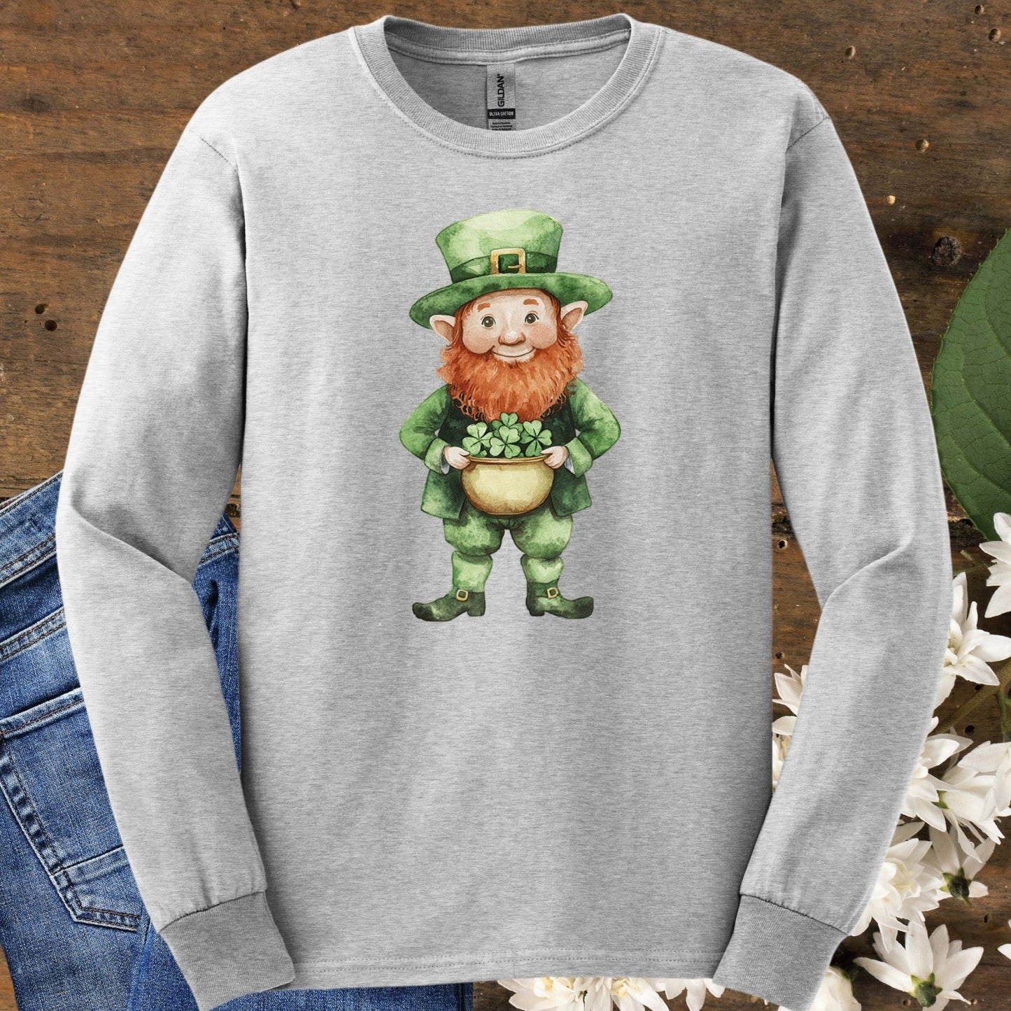 Ash long-sleeve tee with a watercolor leprechaun holding a shamrock pot.