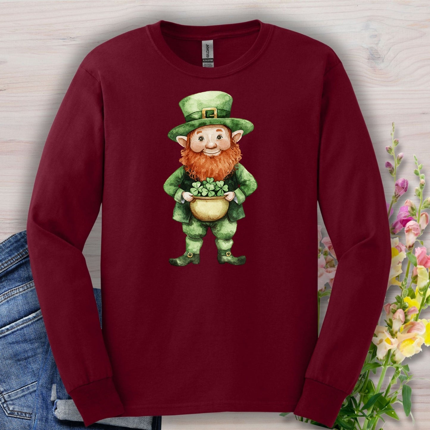 Maroon long-sleeve tee with a watercolor leprechaun holding a shamrock plant.