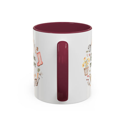 White ceramic 11oz mug with a maroon handle and interior, featuring a "Garden Therapy" floral wreath design.
